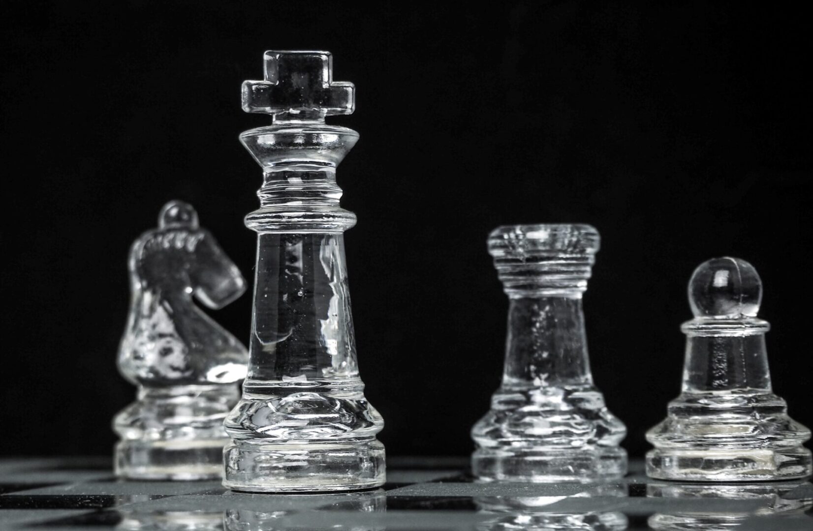 A glass chess set with pieces on the board.