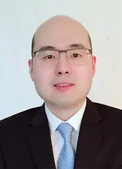 A man in suit and tie with glasses.