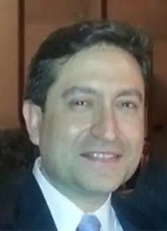 A man in suit and tie smiling for the camera.